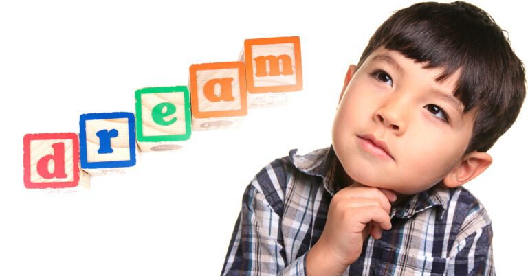 a child next to blocks that spell "dream"