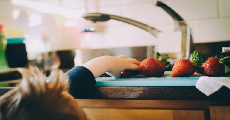 a child grabbing strawberries