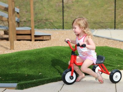 a child on a tricycle at one of our daycare centers